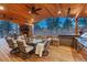 Inviting covered outdoor living area with a stone fireplace, lounge seating, and a fully-equipped outdoor kitchen at 17015 Oxbridge Rd, Monument, CO 80132