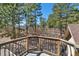 Deck featuring scenic forest views and wood railings at 17015 Oxbridge Rd, Monument, CO 80132