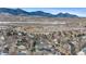 Aerial view of neighborhood showcasing houses, streets, and distant mountain views in winter at 17364 W 63Rd Dr, Arvada, CO 80403