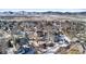 Aerial view of a neighborhood with houses, streets, and a distant mountain range during winter at 17364 W 63Rd Dr, Arvada, CO 80403