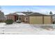 Brick home with two-car garage and snowy front yard at 17364 W 63Rd Dr, Arvada, CO 80403