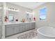 Sleek bathroom with a double vanity, modern gray cabinets, separate soaking tub, and a spacious, bright layout at 890 Coal Bank Trl, Castle Rock, CO 80104