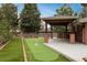 Backyard featuring a putting green, covered patio, and lush landscaping at 5164 E Princeton Ave, Cherry Hills Village, CO 80113