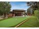 Backyard featuring a putting green, covered patio, and lush landscaping at 5164 E Princeton Ave, Cherry Hills Village, CO 80113