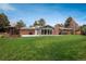 Large backyard showcasing a patio, green lawn, a modern fire pit, steel pergolas, and outdoor entertainment spaces at 5164 E Princeton Ave, Cherry Hills Village, CO 80113