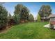 Lush green backyard with mature trees, a wooden fence, and patio space for outdoor enjoyment at 5164 E Princeton Ave, Cherry Hills Village, CO 80113