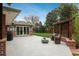 Wide backyard patio with seating, steel pergola, and a modern linear fire pit; sliding glass doors provide home access at 5164 E Princeton Ave, Cherry Hills Village, CO 80113