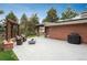 Expansive backyard patio featuring an outdoor kitchen, a pergola with seating, and a modern fire pit feature at 5164 E Princeton Ave, Cherry Hills Village, CO 80113