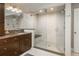 Updated bathroom boasts a walk-in shower with glass doors, modern fixtures, and a sleek vanity with granite counters at 5164 E Princeton Ave, Cherry Hills Village, CO 80113