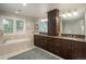 This bathroom has a soaking tub, large vanity with double sinks, sleek fixtures, and neutral tiling at 5164 E Princeton Ave, Cherry Hills Village, CO 80113