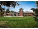 Beautiful backyard view of the home featuring a brick exterior, covered patio and a large grassy area at 5164 E Princeton Ave, Cherry Hills Village, CO 80113
