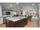 Open-concept kitchen with an island, stainless steel appliances, hardwood floors and view into the dining and living area at 5164 E Princeton Ave, Cherry Hills Village, CO 80113