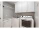 This functional laundry room includes modern washer and dryer units, granite countertops, and ample cabinet space at 5164 E Princeton Ave, Cherry Hills Village, CO 80113
