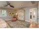A spacious main bedroom with a decorative armoire, rug, ceiling fan, chair, and natural light at 5164 E Princeton Ave, Cherry Hills Village, CO 80113