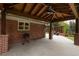 This covered patio features a stained wood ceiling with fan, brick columns, and an outdoor kitchen area at 5164 E Princeton Ave, Cherry Hills Village, CO 80113