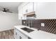 Modern kitchen boasts white cabinets, black hardware, and hexagon tile at 50 E Highline Cir # 102, Centennial, CO 80122