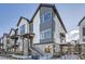 Modern three-story townhome with gray and white siding, brick accents, and a staircase at 5125 Vivian St, Wheat Ridge, CO 80033