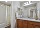 Bathroom featuring a shower and tub, a single sink vanity, and a decorative mirror at 4770 N Jasper St, Denver, CO 80239
