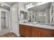 Bathroom featuring double sinks, spacious mirror, and a glass shower at 4770 N Jasper St, Denver, CO 80239