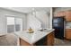 Bright kitchen island with sleek countertops, stainless steel sink and appliances, and wood cabinets at 4770 N Jasper St, Denver, CO 80239