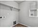 An empty utility room featuring upper shelving, hook-ups for a washer and dryer, and wood flooring at 4770 N Jasper St, Denver, CO 80239
