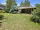 Large grassy backyard with a covered patio and mature trees overhead at 1245 S Forest St, Denver, CO 80246