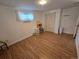 Basement with finished vinyl floors, white walls, window, and storage shelves at 1245 S Forest St, Denver, CO 80246