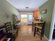 Bright dining area featuring wood floors, a high-top table with stools, and an adjacent kitchen at 1245 S Forest St, Denver, CO 80246