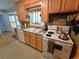 This kitchen features wooden cabinets, grey countertops, a white range, and tile flooring at 1245 S Forest St, Denver, CO 80246