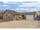 Charming home exterior with a large concrete parking area, garage, and side access door at 235 N 7Th Ave, Brighton, CO 80601