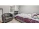 Simple bedroom with a chair, television, window with blinds, and neutral colored walls at 235 N 7Th Ave, Brighton, CO 80601
