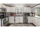 Modern kitchen featuring sleek white cabinets, stainless steel appliances, and stylish backsplash at 235 N 7Th Ave, Brighton, CO 80601