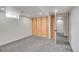 Spacious basement area with gray carpet, white walls, and a partial wall ready for finishing at 3001 Fairfax St, Denver, CO 80207