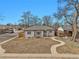 Charming single-story home with a curved walkway and a neatly landscaped front yard under a clear blue sky at 3001 Fairfax St, Denver, CO 80207