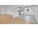 Open living space featuring hardwood floors flowing into the kitchen with white cabinetry and modern appliances at 3001 Fairfax St, Denver, CO 80207