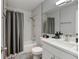 Well-lit bathroom features a shower and tub with gray shower curtain and white vanity at 8600 E Alameda Ave # 17-105, Denver, CO 80247
