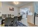 Bright dining room adjacent to a modern kitchen with white cabinets and stainless steel appliances at 8600 E Alameda Ave # 17-105, Denver, CO 80247