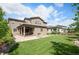 Spacious backyard with a well-maintained lawn, covered patio, and lush landscaping at 2130 S Poppy St, Lakewood, CO 80228