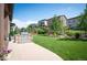 Landscaped backyard features a stone grill area, grassy area, and manicured greenery at 2130 S Poppy St, Lakewood, CO 80228