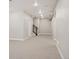 Finished basement with neutral carpet and trim, leading to stairs, door, and utility access at 2130 S Poppy St, Lakewood, CO 80228