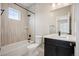 This bathroom features neutral tiling, a shower and tub combination, and dark cabinets at 2130 S Poppy St, Lakewood, CO 80228