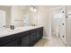 This bathroom features a dual sink vanity, dark cabinets, modern faucets, and tile flooring at 2130 S Poppy St, Lakewood, CO 80228