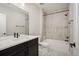 This bathroom features neutral tiling, a shower and tub combination, and dark cabinets at 2130 S Poppy St, Lakewood, CO 80228