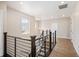 Second floor hallway with hardwood floors and a staircase with modern wrought iron railing at 2130 S Poppy St, Lakewood, CO 80228