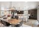 Inviting space with dark cabinetry, stainless appliances, an island with seating, seamlessly connected to the dining area at 2130 S Poppy St, Lakewood, CO 80228