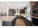 Modern kitchen featuring dark cabinets, stainless steel appliances, and a large island with seating at 2130 S Poppy St, Lakewood, CO 80228