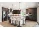 Bright kitchen featuring dark cabinets, stainless steel appliances, and a spacious center island with barstool seating at 2130 S Poppy St, Lakewood, CO 80228