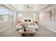 Serene main bedroom with tray ceiling, large windows, and stylish seating area at 2130 S Poppy St, Lakewood, CO 80228