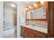 Classic bathroom featuring floral wallpaper, wooden cabinetry, vanity with sink, and a bathtub with shower at 7801 W 35Th Ave # 405, Wheat Ridge, CO 80033
