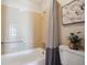 Standard bathtub with tiled walls, shower curtain, toilet, and a decorative flower picture at 7801 W 35Th Ave # 405, Wheat Ridge, CO 80033